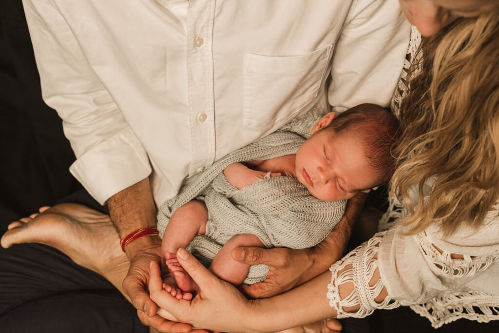 Babyfotografie Frankfurt, Eltern halten ihr Neugeborenes in den Händen.