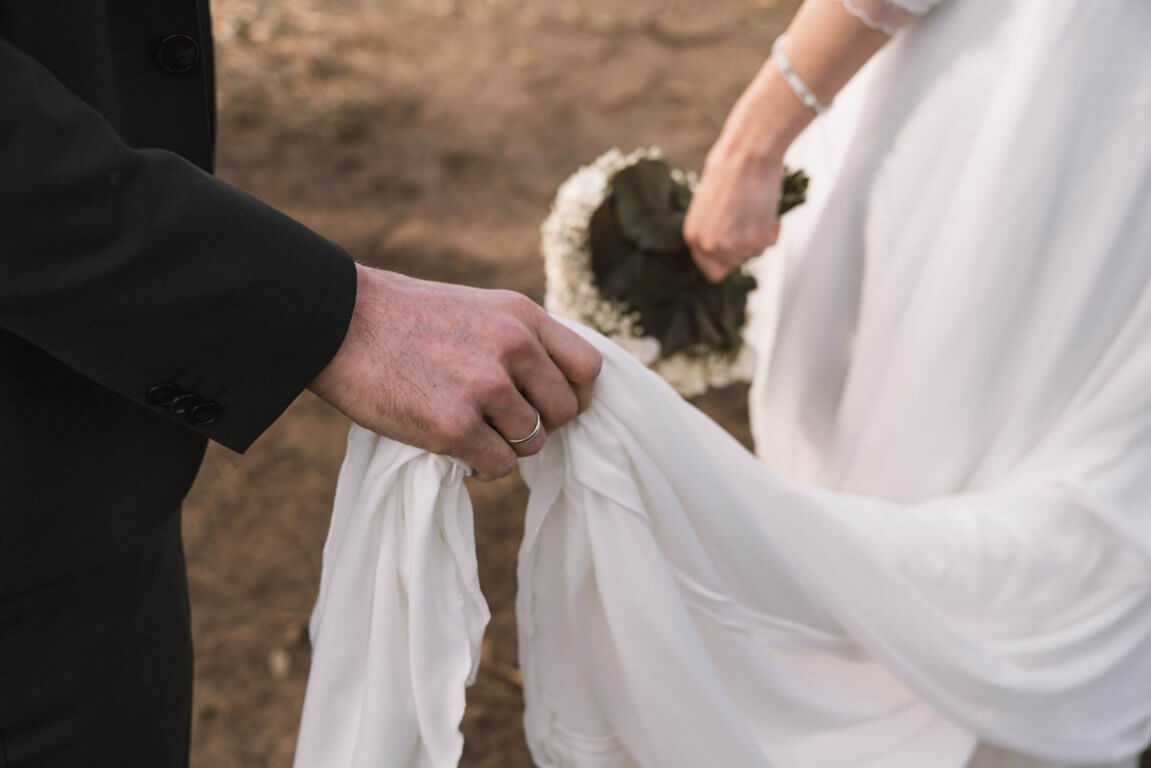 Bräutigam hält in der Ringhand das Brautkleid