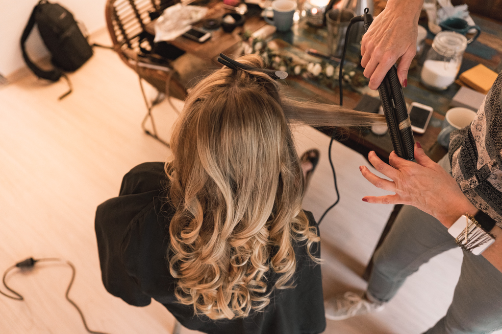 Braut bekommt die Haare gestyled