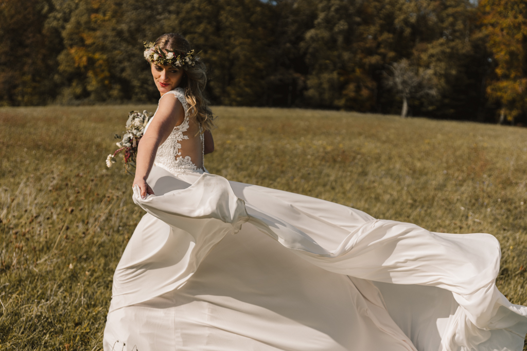 Braut lässt ihr Brautkleid im Wind wehen.