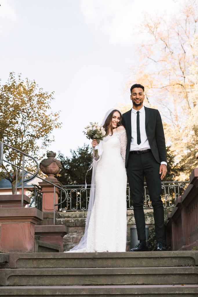 Brautpaar steht auf der Treppe voller Freude nach der standesamtlichen Hochzeit.