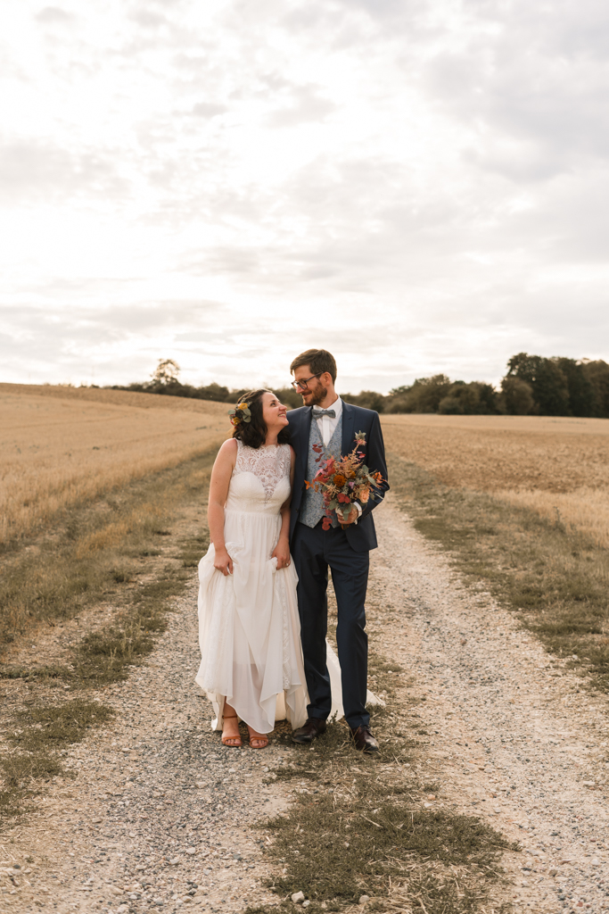 Das Fotoshooting in Frankfurt, das Hochzeitpaar steht auf einem Weg und strahlt sich an.