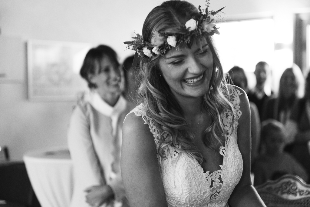 Braut lacht voller Emotionen in die Kamera während der Hochzeit.