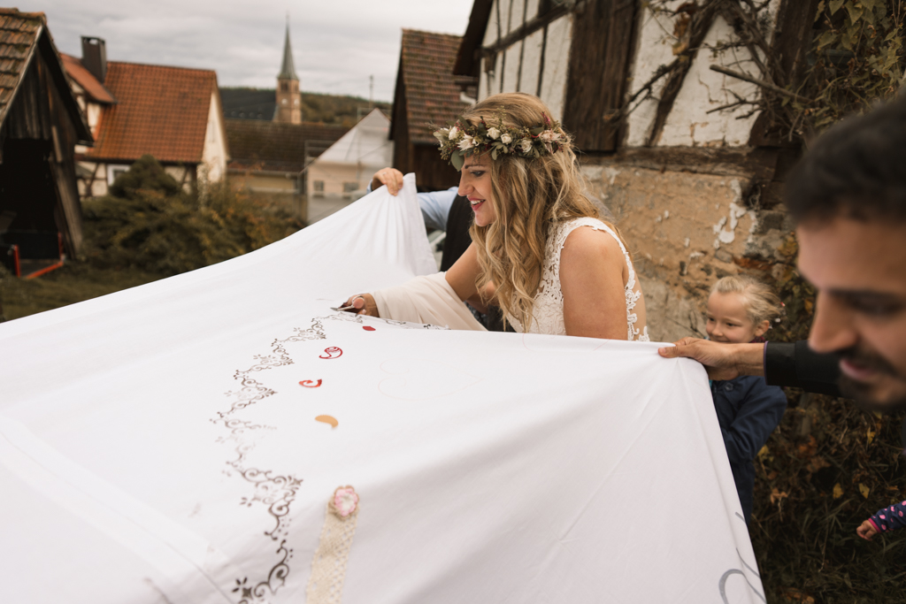 Braut zerschneidet mit Hochzeitslacken mit einer Nagelschere.