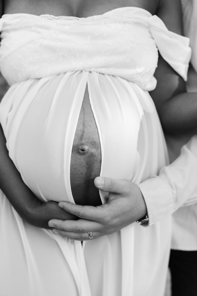 Babybauch mit den Händen von Mama und Papa.