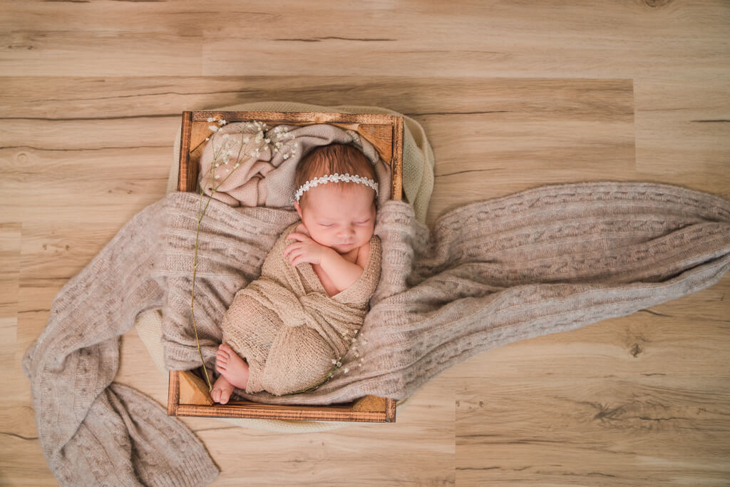 Babyfotografie Frankfurt von dem kleinen Mädchen in einer Weinkiste.