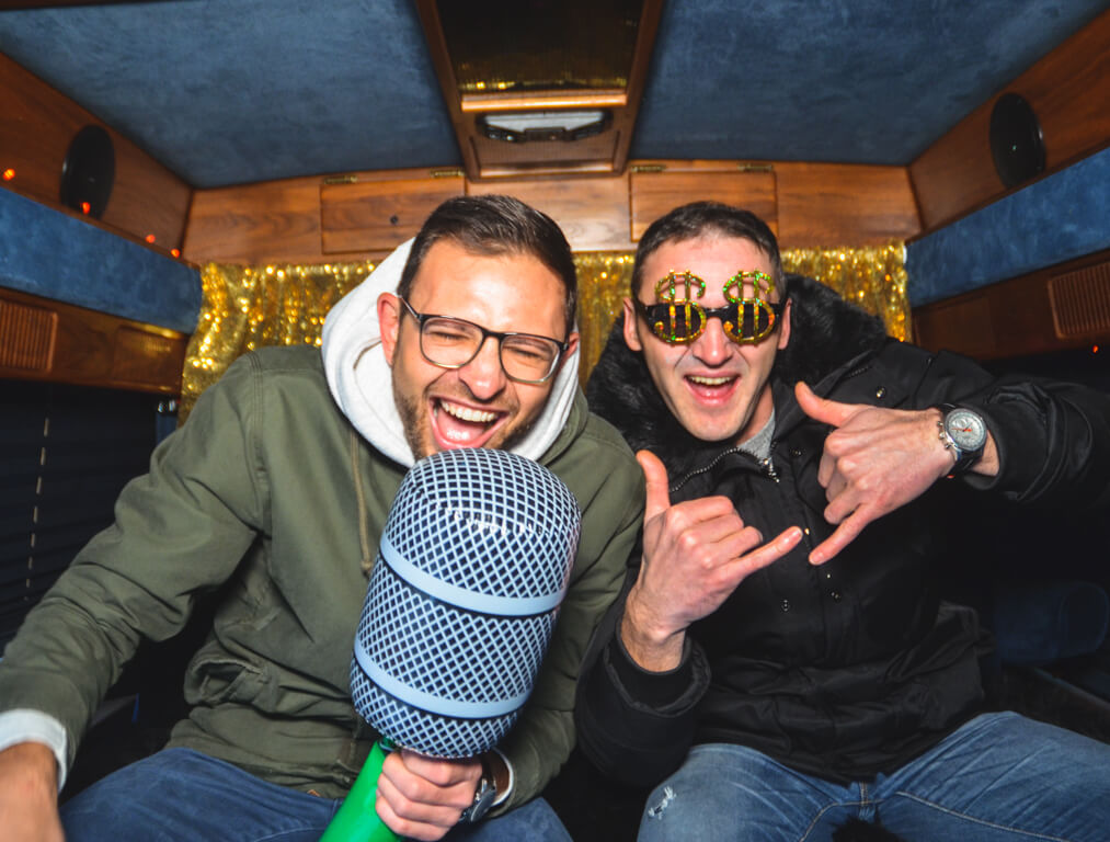 Zwei Männer sitzen im Fotobus Big Eddie und machen ein Selfie mit riesen Mikrofon.