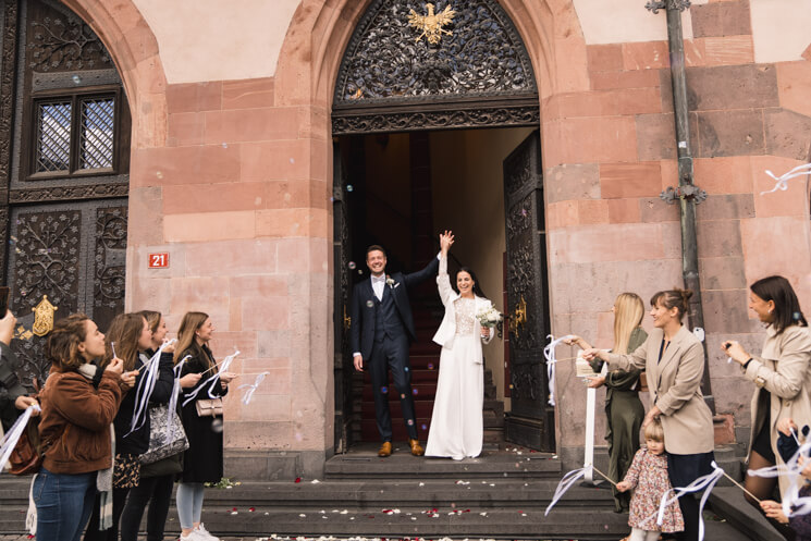 Brautpaar und Hochzeitsgäste jubeln, als das Paar das Standesamt Frankfurt Römer nach Vollziehung der Ehe verlässt.