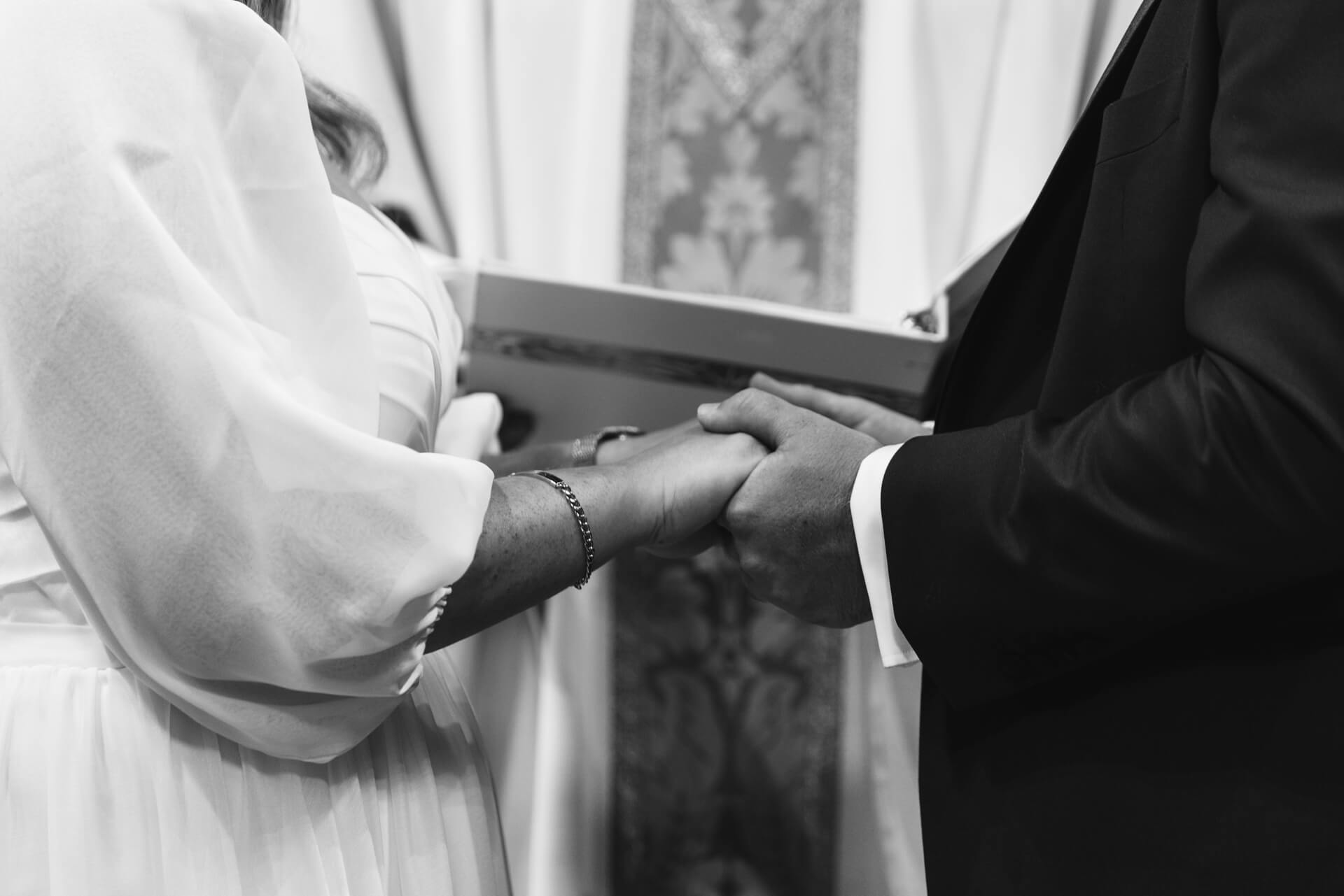 Brautpaar hält für das Eheversprechen in der Kirche die Hände.