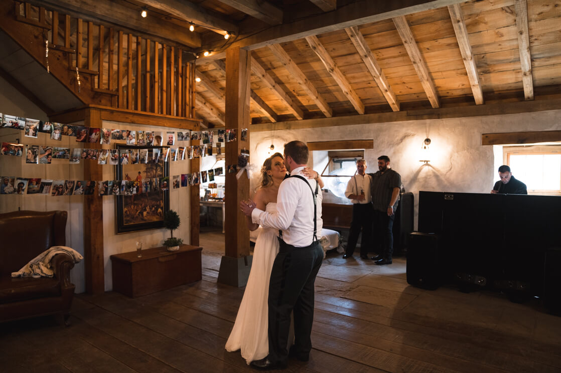 Brautpaar tanzt in einer rustikalen Hochzeitslokation.