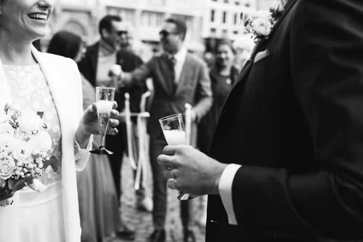 Brautpaar halten beide ein Sektglas in der Hand.